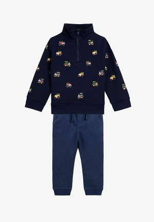 Donkerblauwe ritsvest met tractorpatronen, gecombineerd met bijpassende donkerblauwe joggers met een elastische tailleband en zakken.
