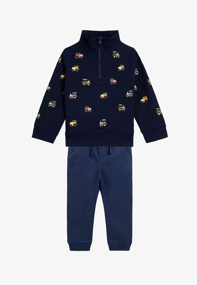 Tumed zip-up sweatshirts traktorite mustriga, koos sobivate tumepruunide sportpükstega, millel on elastne vöökoht ja taskud.