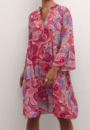 Robe imprimée paisley rose avec un col en V, des manches trois-quarts et une jupe à volants. Tissu léger avec une texture fluide et des couleurs vives.