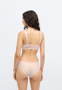 Σετ ροζ εσώρουχα ανοιχτού ροζ χρώματος με απλό σχέδιο, λεπτές τιράντες, απαλό ύφασμα και διακριτικό ριγέ μοτίβο στην πίσω πλευρά του στηθόδεσμου.