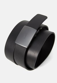 Sort læderbælte med en mat finish, der har en rektangulær, metallisk spænde ætset med "HUGO." Designet er strømlinet og moderne.