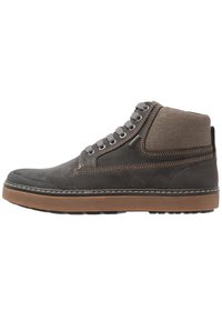 Zapatilla alta de ante gris con parte superior de lona, suela de goma marrón y costuras en contraste. Los ojetes y los cordones son de color gris metálico.