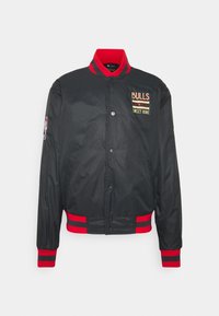 Sort bomberjakke med røde og sorte stribede ribbede manchetter og kant. Har brodering af "BULLS" og "SWEET HOME". NBA-logo på ærmet.