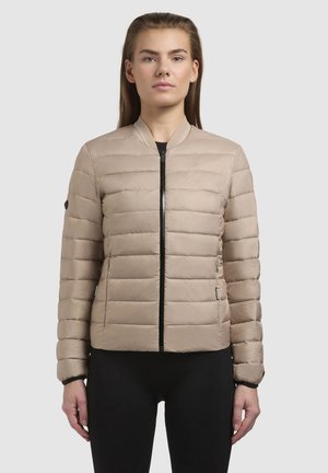 Beige gewatteerde jas met een ritssluiting aan de voorkant, een geribde kraag en zwarte accenten. Heeft horizontale stiksels en zijzakken. Lichtgewicht materiaal.
