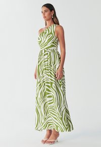 Maxikleid mit einem Schulterträger im grün-weißen Zebramuster, mit tailliertem Oberteil und fließendem Rock. Der Stoff wirkt leicht und strukturiert.