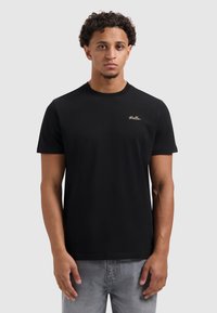 Zwarte katoenen T-shirt met ronde hals en korte mouwen, voorzien van een subtiele gouden borduursel "Ballin" op de linkerborst.