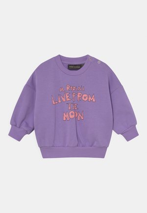 Paars peutertrui met roze tekst "M. Rodina live from the moon," geribbelde boorden en zoom, en drukknoopjes op de linkerschouder.