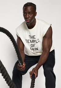Nike Performance TEE GYM CULTURE - Tricou cu imprimeu - pale ivory