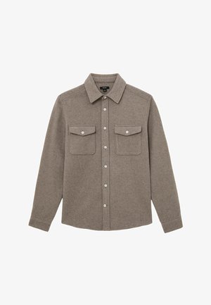 Brun langærmet skjorte med knapper og to brystlommer med klap samt spidst krave, lagt fladt ud på en hvid baggrund.