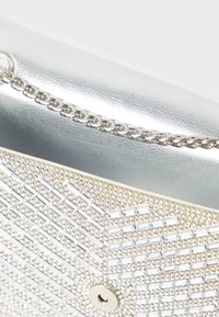 Poșetă clutch argintie cu curea metalică, decorată cu mărgele cristale dreptunghiulare și rotunde aranjate într-un model geometric.