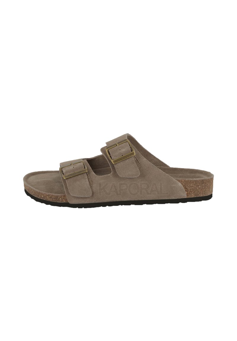 Sandales en suédine beige avec deux brides réglables et boucles dorées. Semelle en liège avec une semelle extérieure en caoutchouc noir texturé. Nom de la marque embossé sur le côté.