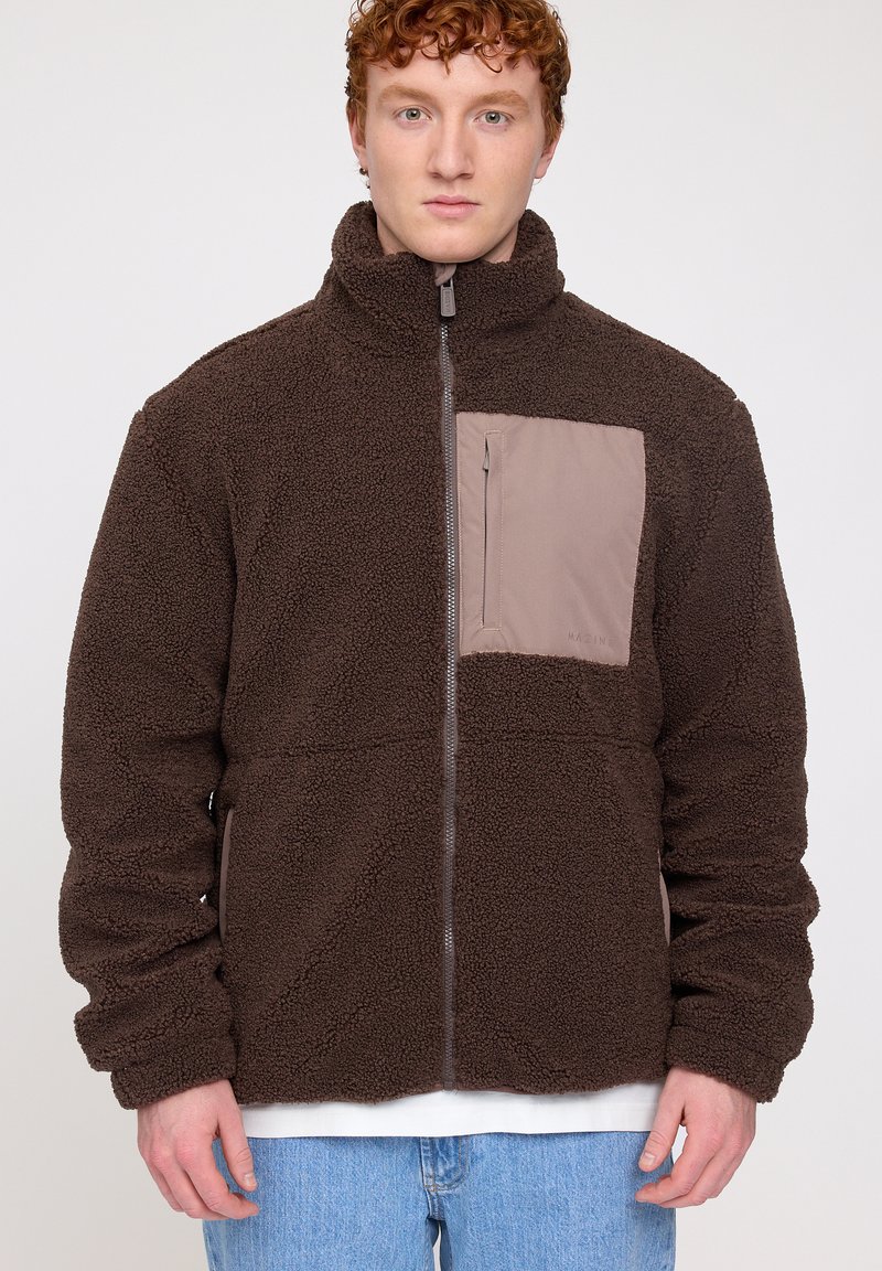 Brown fleece jacket with a high collar, zippered front, and beige chest pocket. The fabric has a soft, textured appearance, suitable for casual wear.