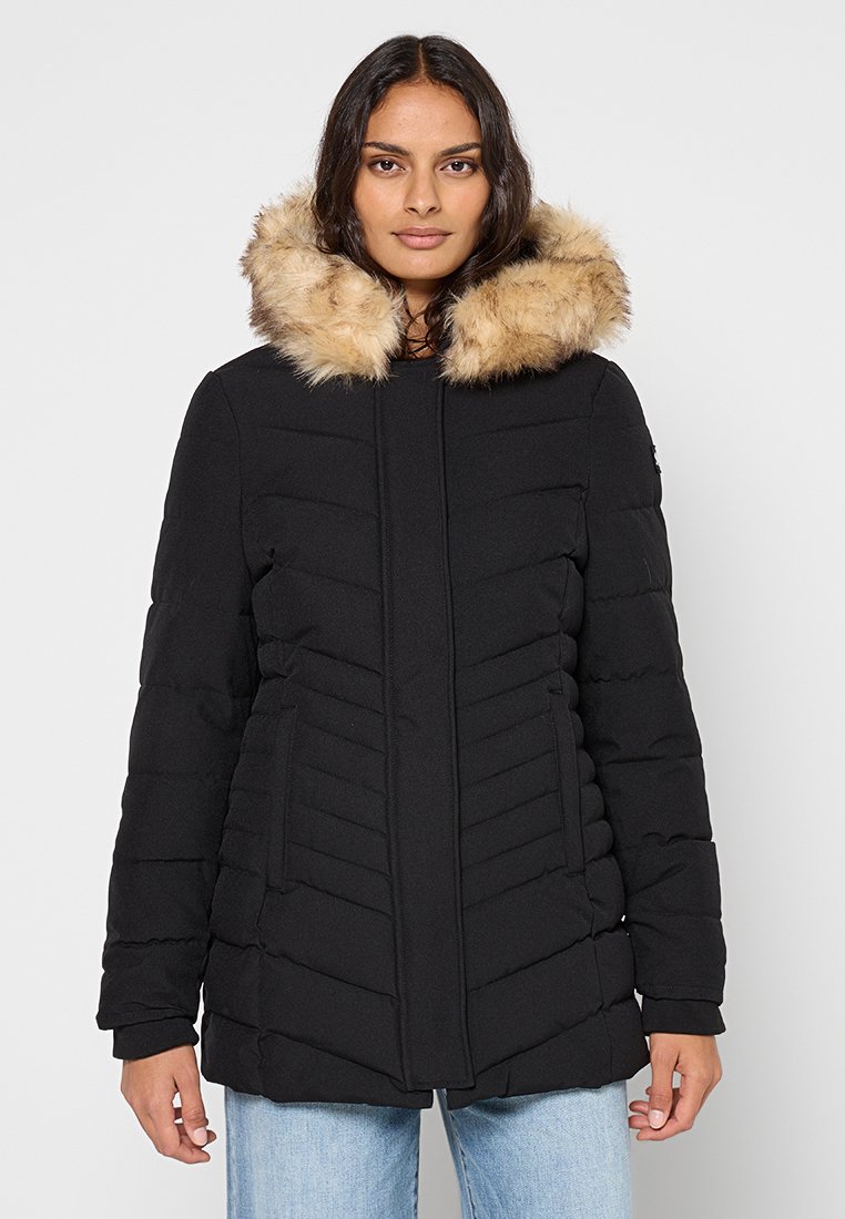 Czarna pikowana kurtka z sztucznym futerkiem na kołnierzu, z pionowym przeszyciem, zamkiem błyskawicznym z przodu oraz bocznymi kieszeniami.