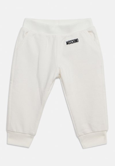 Pantalon de survêtement blanc pour tout-petit avec poignets et taille élastiques, poches latérales et logo Moschino noir sur le devant côté droit.