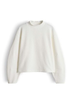Pull-over blanc texturé avec un col haut et arrondi et des manches longues. Design court, tissu doux et silhouette carrée.