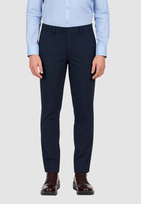 Pantaloni da abito blu con vestibilità slim, realizzati in un tessuto liscio. Presentano una vita piatta, passanti per la cintura e una chiusura con un singolo bottone.
