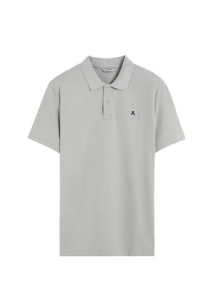 Polo de color gris claro hecho de algodón, con un cuello clásico, tapeta de dos botones y un pequeño logo de calavera en navy en el lado izquierdo del pecho.