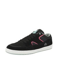 Musta nappa sneaker vaaleanpunaisilla yksityiskohdilla, valkoinen kumipohja ja teksturoitu verkkomateriaali. Ominaisuuksiin kuuluu nauhoitus edessä ja logo sivulla.