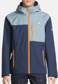 Herrarnas vattentäta jacka med en ljusblå övre del, mörkblå nedre del och orange dragkedjor. Inkluderar en huva och framfickor.