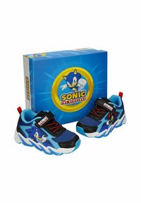 Baskets pour enfants de couleur bleu et noir à l'effigie de Sonic le Hérisson, avec des lacets rouges et des impressions du personnage, présentées avec une boîte à chaussures assortie sur le thème de Sonic.