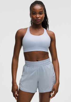 Hellblauer Sport-BH kombiniert mit passenden hellblauen Shorts. Beide Kleidungsstücke verfügen über eine glatte Textur und einen elastischen Taillengummi für zusätzlichen Komfort.