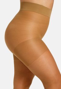 Calze thigh-high sheer color sabbia con una larga fascia liscia nella parte superiore. Il tessuto è leggero e leggermente lucido, coprendo la parte superiore della coscia.