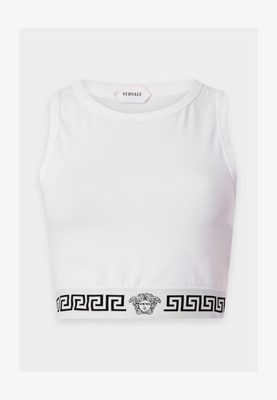Débardeur court blanc avec motif clé grecque noir et logo tête de Méduse sur la bande inférieure, étiqueté Versace à l'intérieur de l'encolure.