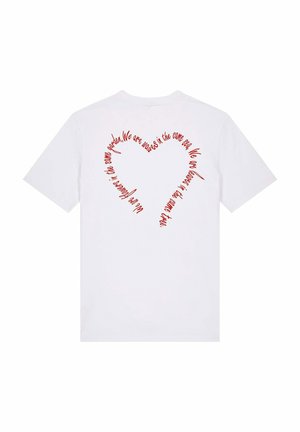 T-shirt blanc avec un design textuel circulaire rouge au dos, ressemblant à une forme de cœur dans un style manuscrit. Matériau en coton doux.
