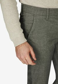 Grau maßgeschneiderte Hose mit flachem Bund, Seitentaschen und subtiler Struktur. Sichtbare Nähdetails und ein Slim-Fit-Design.