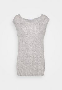 T-shirt à manches courtes avec un décolleté rond, présentant un fond blanc avec des taches noires, en tissu doux et légèrement extensible.