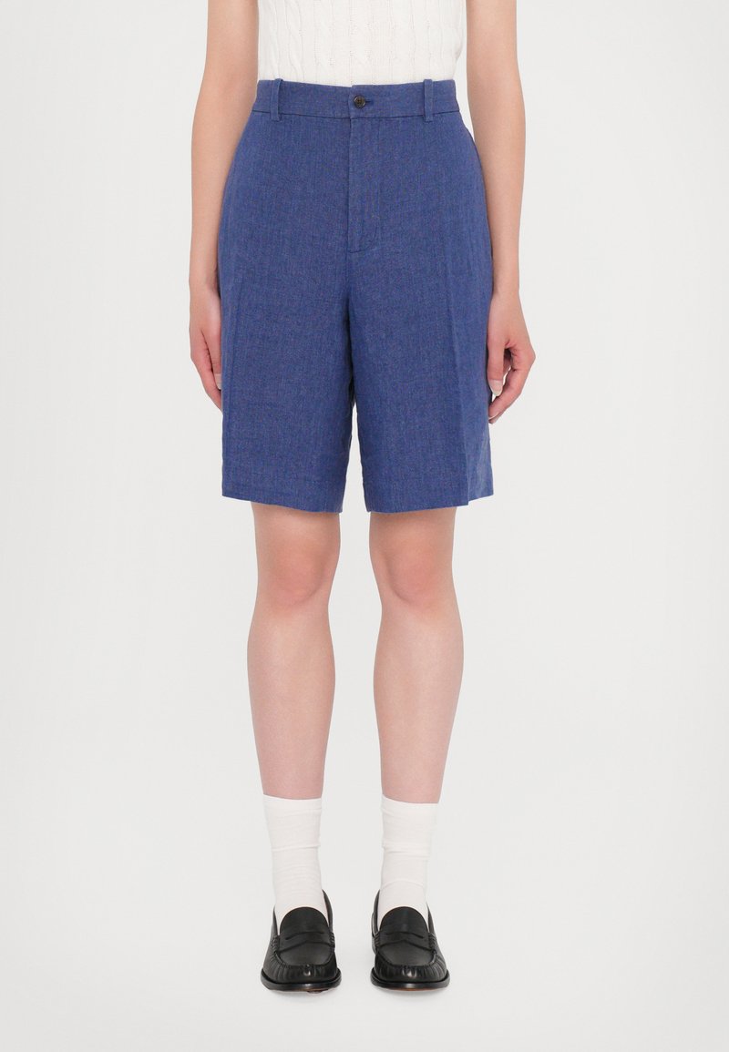 Shorts bleu ajustés en tissu texturé, dotés d'une fermeture à bouton, de poches latérales et d'une coupe droite au-dessus du genou.