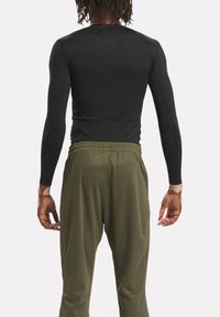Black long-sleeve top paired with olive green athletic pants. The top is fitted, while the pants have an elastic waistband and tapered legs.
