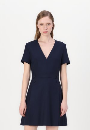 Navy blue dress with a V-neck, short sleeves, and a flared skirt. Features two decorative buttons at the waist and smooth texture.