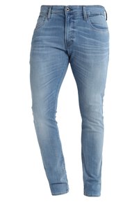 Jeans de denim azul claro con corte ajustado, que cuentan con una cinturilla de altura media, un sutil desgaste y un diseño de cinco bolsillos. Textura suave.