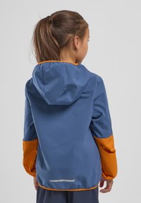Giacca con cappuccio blu e arancione realizzata in tessuto liscio e leggero. Presenta maniche a contrasto e un accento riflettente sulla schiena.