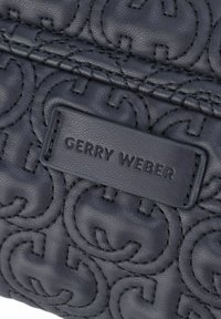 Borsa a tracolla in pelle navy con motivo a rombi e logo impresso. Presenta un'etichetta rettangolare con il testo "GERRY WEBER" in una finitura discreta.