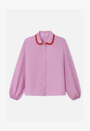 Roza bluza s crvenim izvezenim ovratnikom, dugim rukavima s elastičnim manžetnama i sprijeda na kopčanje na gumbe. Glatka tkanina, dizajn opuštenog kroja.