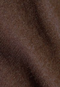 Brązowy materiał o delikatnej prążkowanej teksturze, lekka tkanina z lekkim połyskiem, prezentująca subtelne różnice w kolorze.