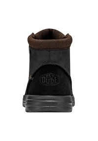 Stivale in suede nero con un colletto in tessuto marrone e una suola in gomma nera. Presenta un marchio sul retro. Design semplice e minimalista.