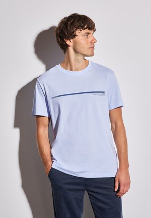 T-shirt en coton bleu clair avec un col rond et des manches courtes. Présente une ligne imprimée bleu foncé et du texte sur la poitrine.