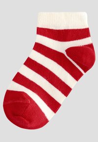 Rood-wit gestreepte enkelsok met rode teen en hiel, en een witte boord op een lichtgrijze achtergrond.