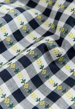 Cotton fabric with a navy and white check pattern, featuring yellow flower embroidery on green stems and a textured weave.