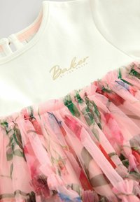 Biała sukienka z różową tiulową nakładką w kwiatowy wzór. Złoty napis "Baker by Ted Baker" na dekolcie, miękki materiał, okrągły dekolt.