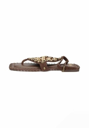 Sandalo in pelle marrone con borchie dorate decorative e fibbia alla caviglia, suola piatta con dettaglio di bordo intrecciato.
