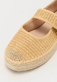 Kerek orrú, szőtt espadrille bézs színben, elasztikus pánttal és varrott juta talppal. Simogatásra kellemes belső bélés.