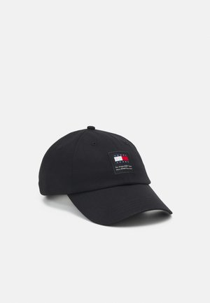 Gorra de béisbol negra hecha de algodón con visera curva. Cuenta con un parche de logo rectangular en colores rojo, blanco y azul. Diseño sencillo.