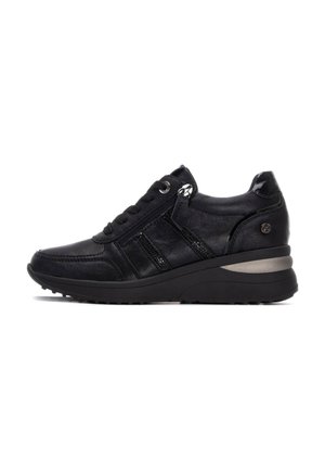 Zapatilla de cuero negra con acentos texturizados, diseño de cordones, cremallera lateral y una suela negra gruesa con una franja plateada en el talón.