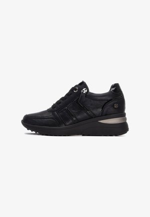 Zapatilla de cuero negra con acentos texturizados, diseño de cordones, cremallera lateral y una suela negra gruesa con una franja plateada en el talón.