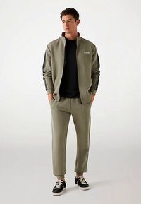 Guess Užtrauktuku užsegamas treningas - hellgrün