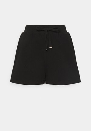 Pantaloncini neri realizzati in tessuto morbido, con vita elastica e coulisse e tasche laterali. Orlo piatto senza motivi o dettagli.